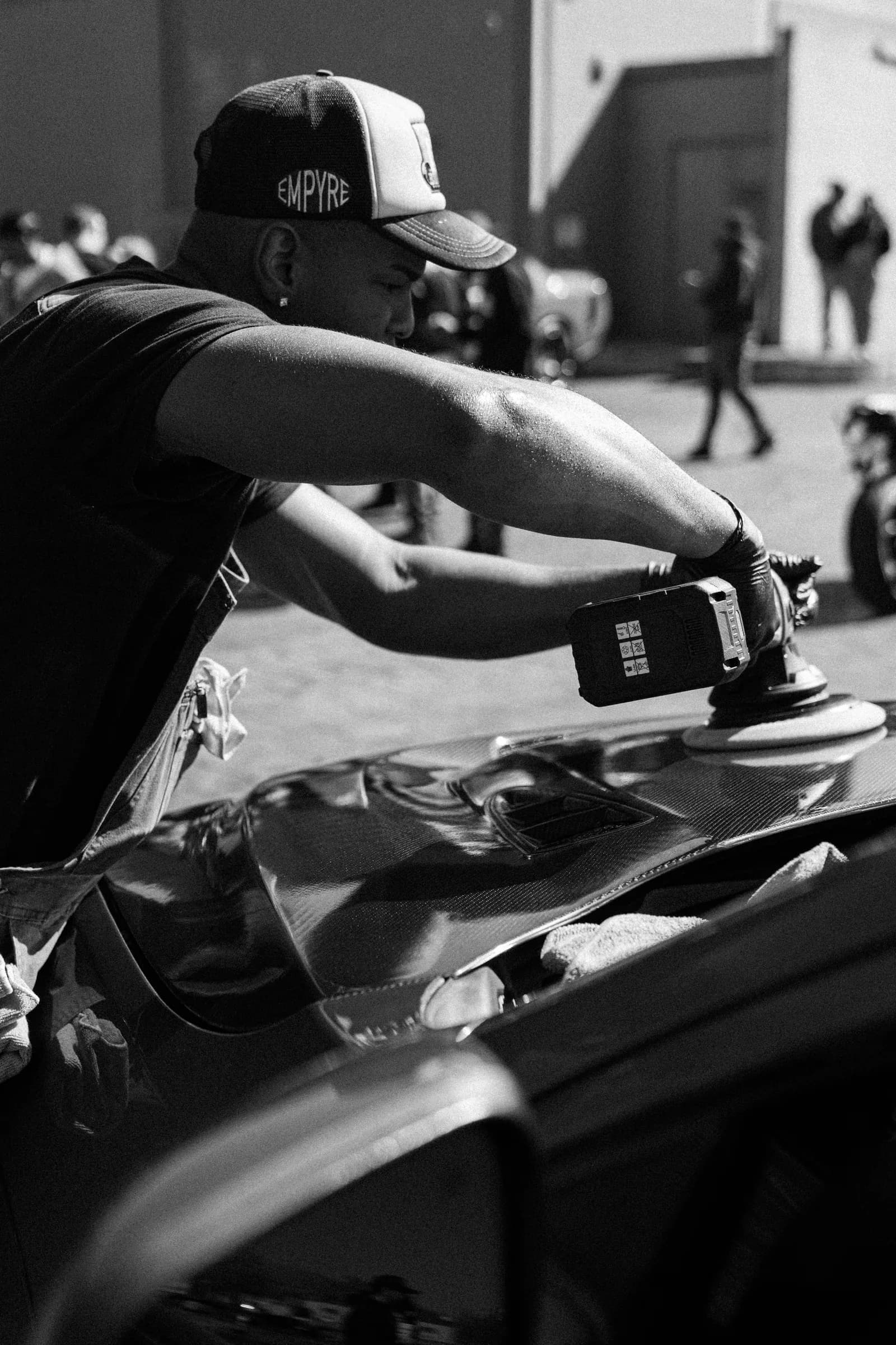 A Showroom Shine detailer running a dual-action polisher across a car hood